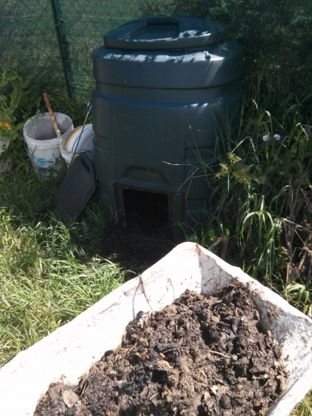 Un composter in fase di rimozione del compost pronto